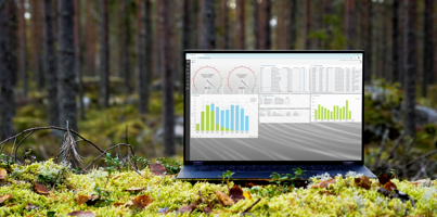 A laptop computer sitting on top of a moss covered field.