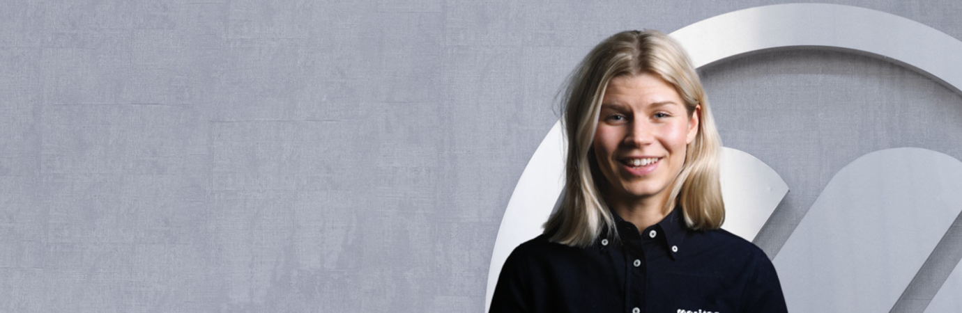 En kvinna står framför en vägg.