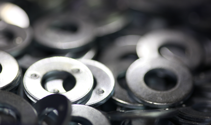 A pile of metal washers sitting on top of a table.