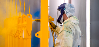 A man in a protective suit spray painting a wall.