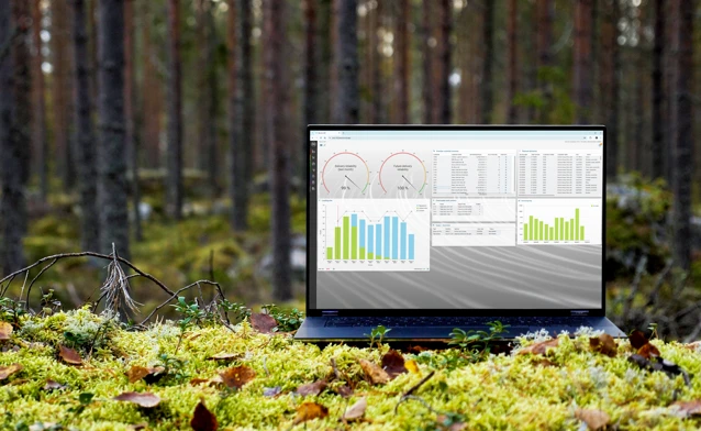 A laptop computer sitting on top of a moss covered field.