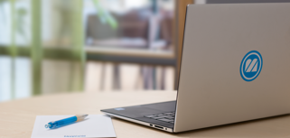 A laptop computer sitting on top of a wooden table.