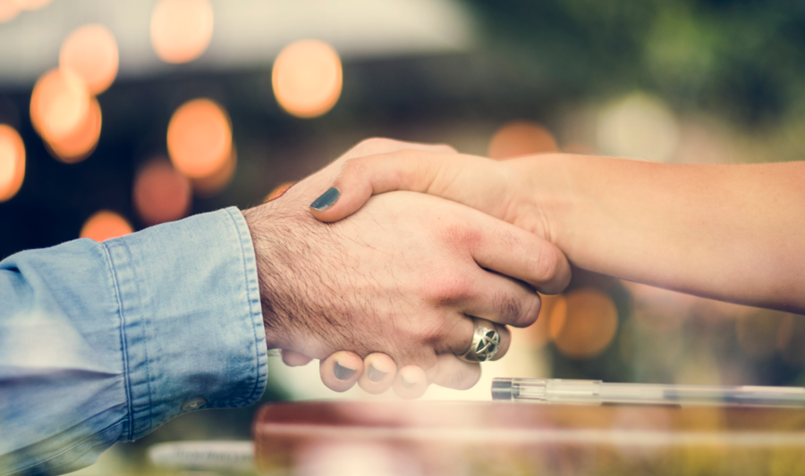 A close up of two people shaking hands.