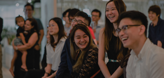 Personer sitter i grupp och skrattar tillsammans. 