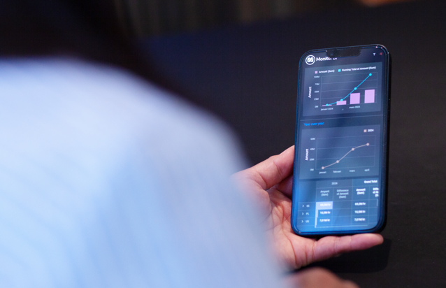 Trzymany w ręku telefon komórkowy z pulpitem nawigacyjnym systemu Monitor ERP