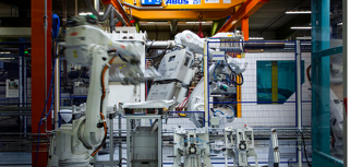 En stor maskin i en byggnad med en lyftkran i bakgrunden.