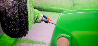 A green machine with a hose connected to it.