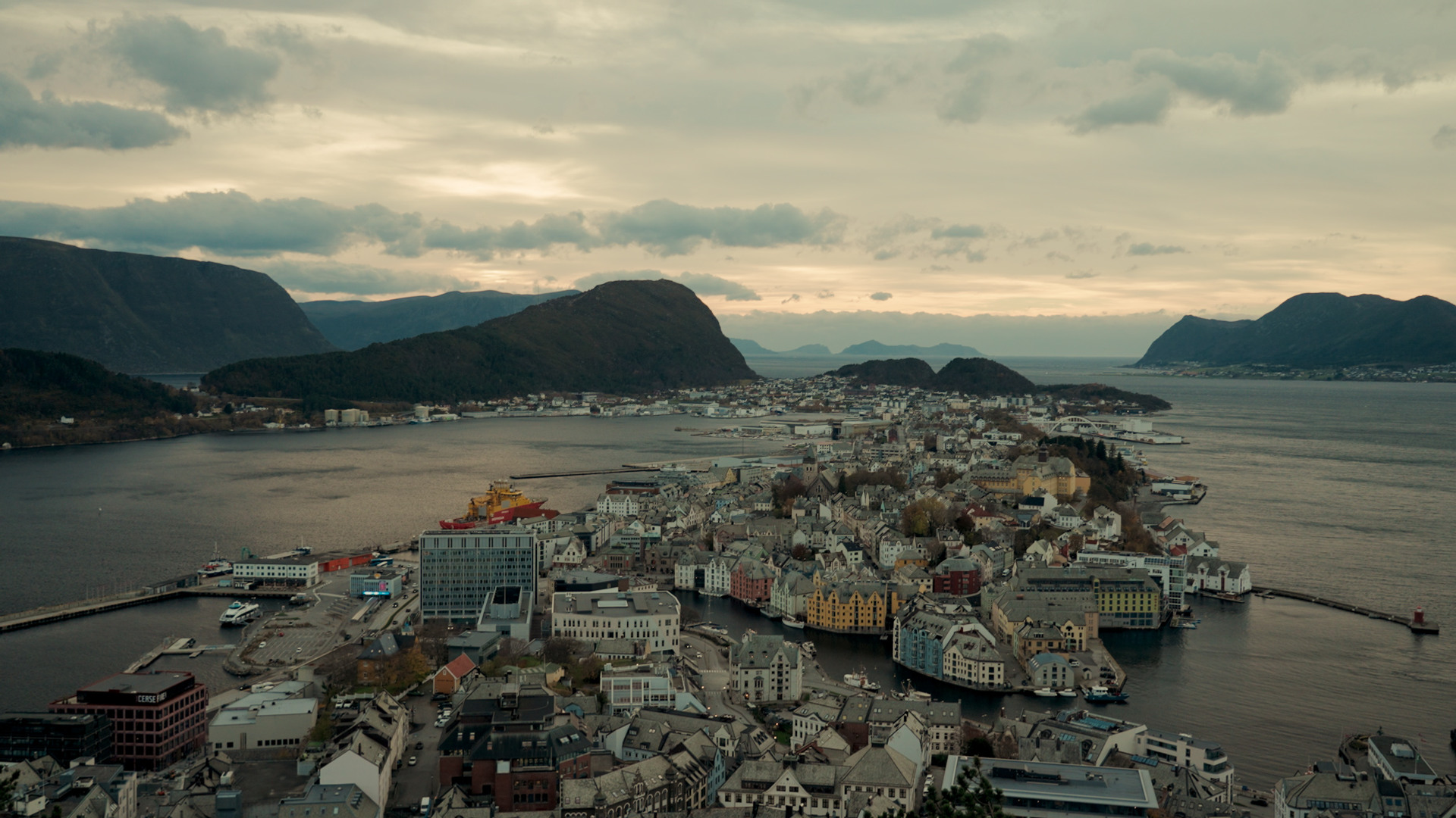 Oversiktsbilde av Ålesund, Norge, med fjorder, øyer og sentrum i kveldssol.
