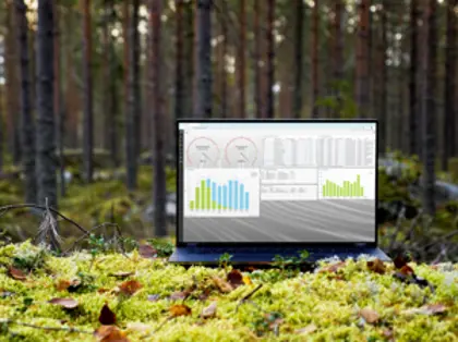En bärbar dator som står i en skog. Datorn visar en vy i Monitor ERPs hållbarhetsfunktion. 