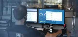 A man sitting in front of a computer monitor.