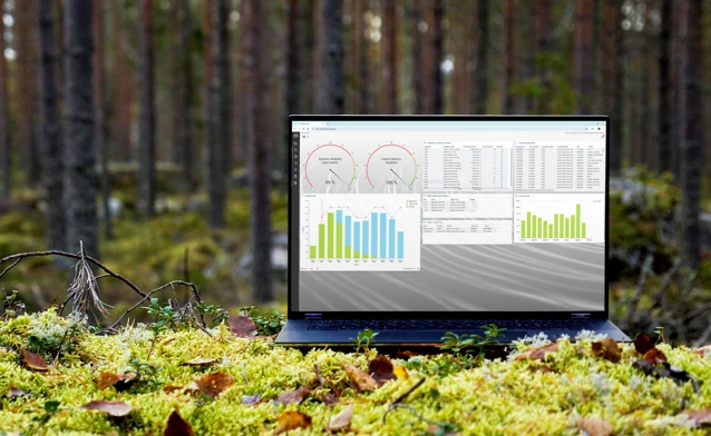 A laptop computer sitting on top of a moss covered field.