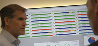 Två män står framför en datorskärm.